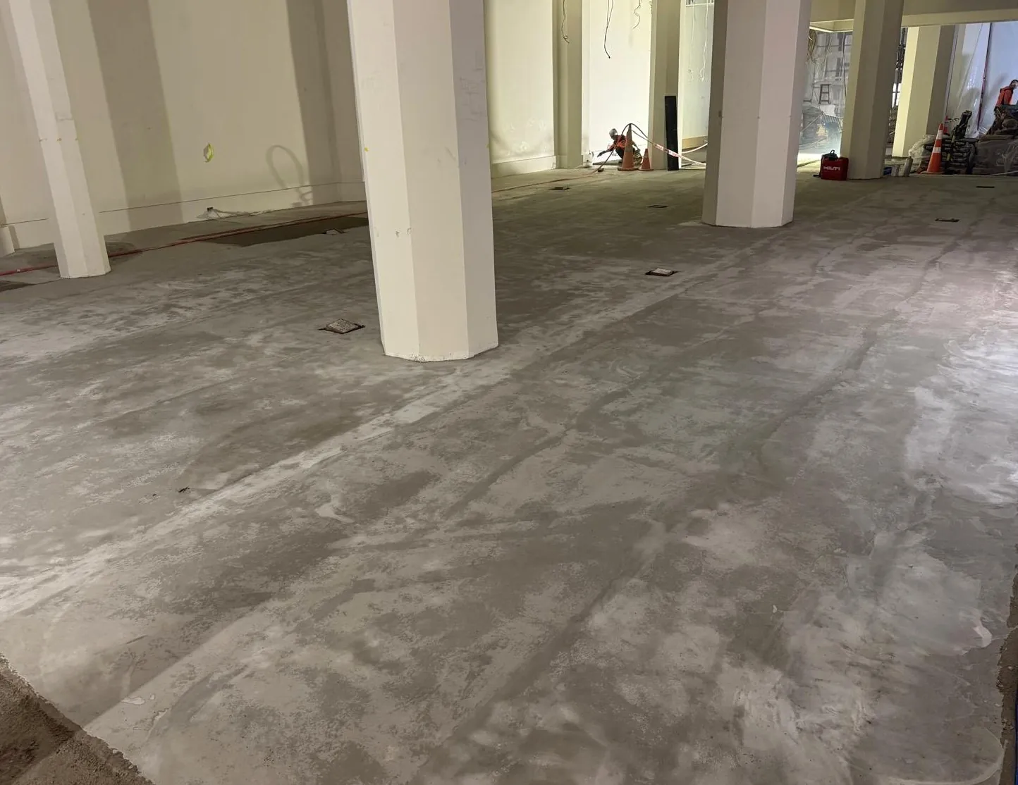 Prepared screeded floor around columns in a commercial interior under construction