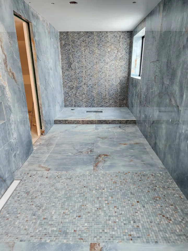 Blue veined shower panels with a patterned feature wall