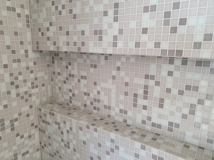 Close view of mosaic tiles around a shower niche