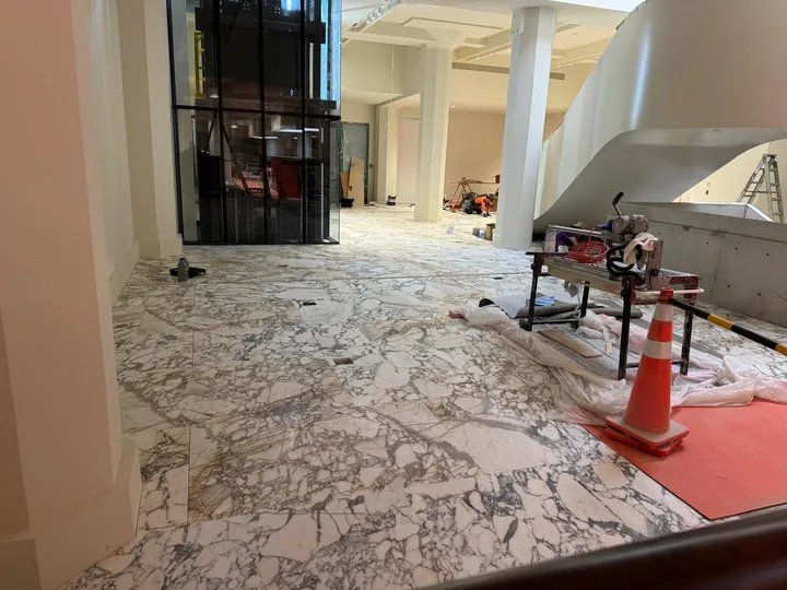 Wide view of patterned stone flooring in an interior under construction